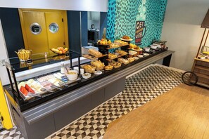 Un espace buffet proposant une variété de plats et un coin café.
