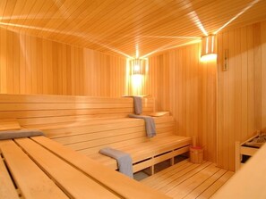 Eine Sauna mit Holzbänken und einer Bank mit Handtuch.