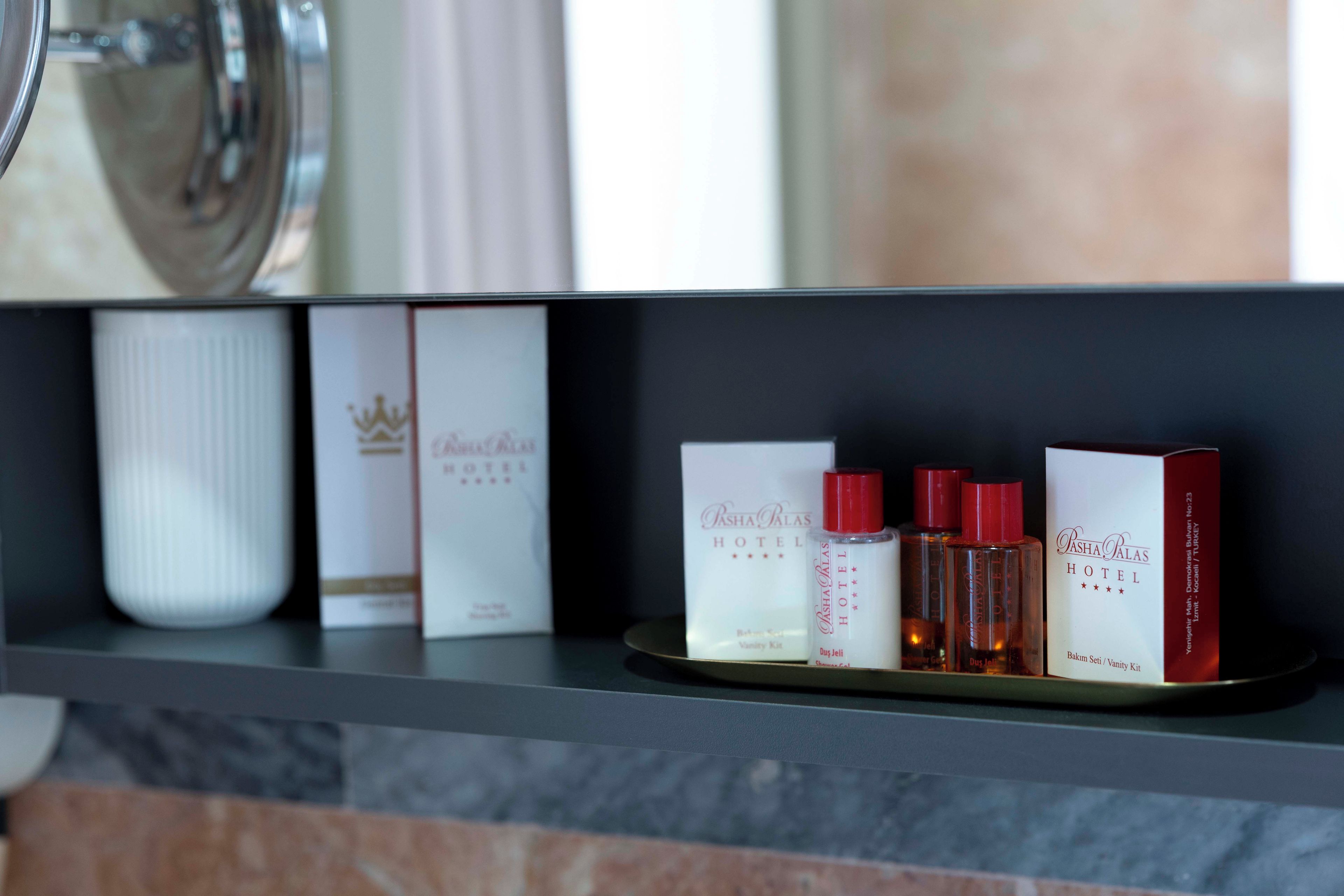 A hotel shelf with branded boxes and toiletries.