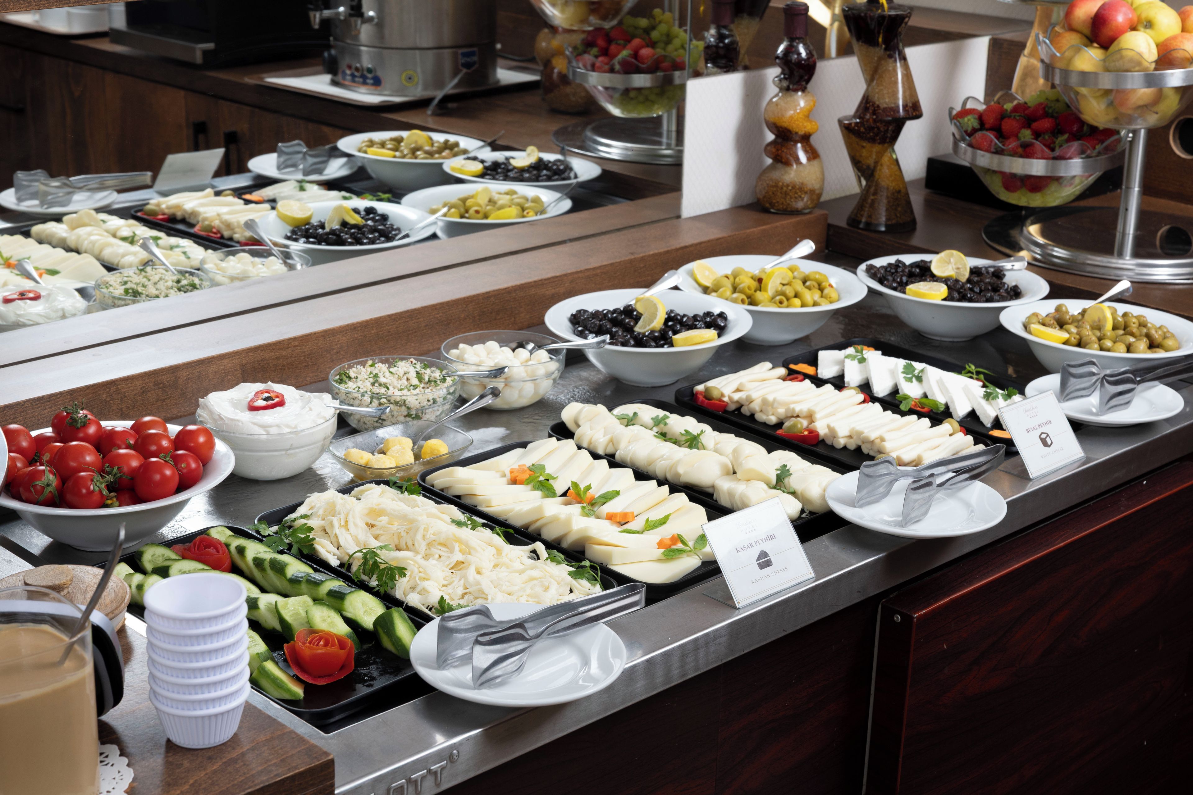 Un buffet proposant une variété de plats, notamment des salades, des fruits et des fromages.
