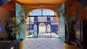 An arched entrance with a checkered floor, potted plants, and a view of the outside. - Riad Dar Naima Imsouane (Imsouane)