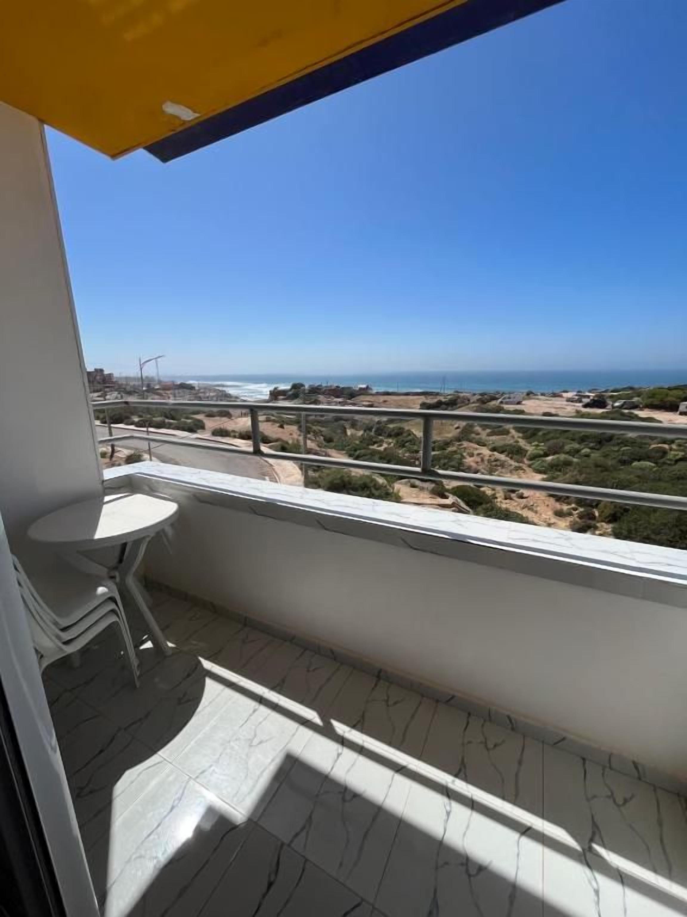Ein Balkon mit freiem Blick auf Strand und Meer.