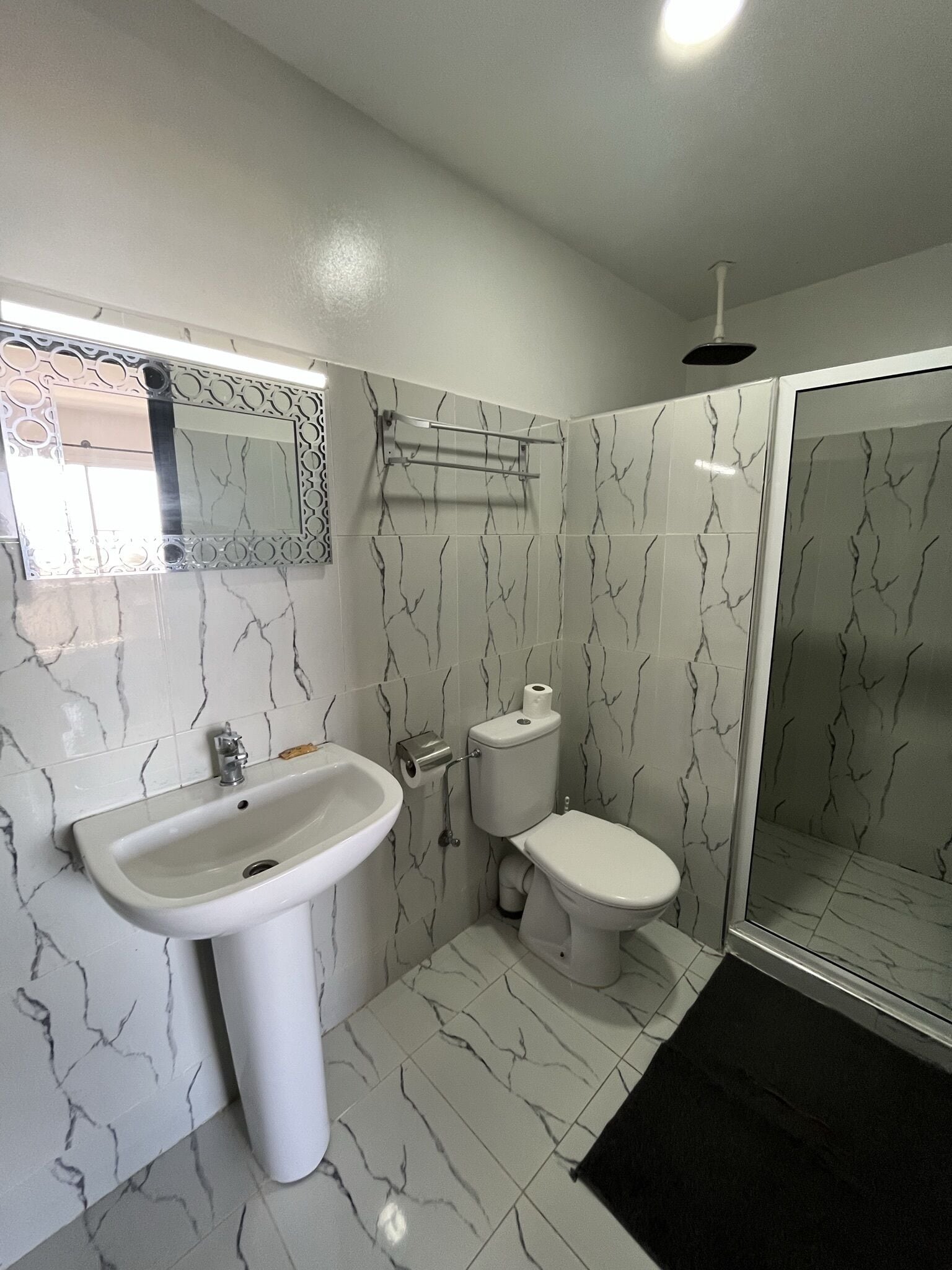 A bathroom with a sink, toilet, and shower.