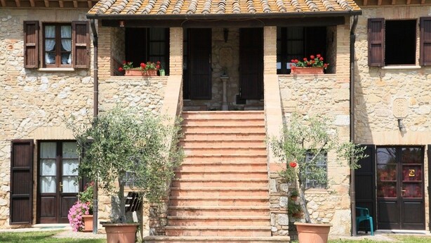 A stone building with a tiled roof, a central staircase, and potted plants. - Podere Agrituristico Luchiano (Amelia)