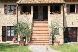 A stone building with a tiled roof, a central staircase, and potted plants. - Podere Agrituristico Luchiano (Amelia)