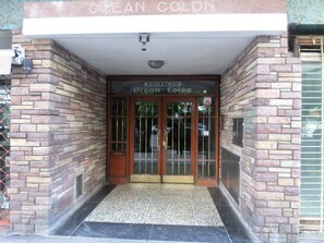 Entrada de un edificio con suelo de baldosas y un letrero que dice 'Ocean Colon'.