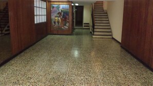 A hallway with a tiled floor, wooden walls, and a staircase leading to an upper level. - Departamento MDQ Colon by EF (Mar del Plata)
