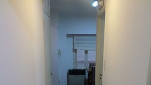 A narrow hallway with wooden flooring and white walls. - Departamento MDQ Colon by EF (Mar del Plata)