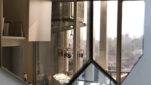 Une cuisine moderne équipée d’appareils électroménagers en acier inoxydable, d’un four à micro-ondes et d’une machine à café.