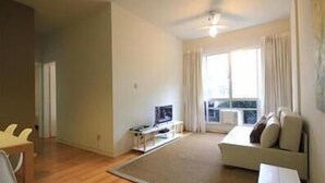 Ein modernes Wohnzimmer mit einer Couch, einem Couchtisch und einem Fernseher.