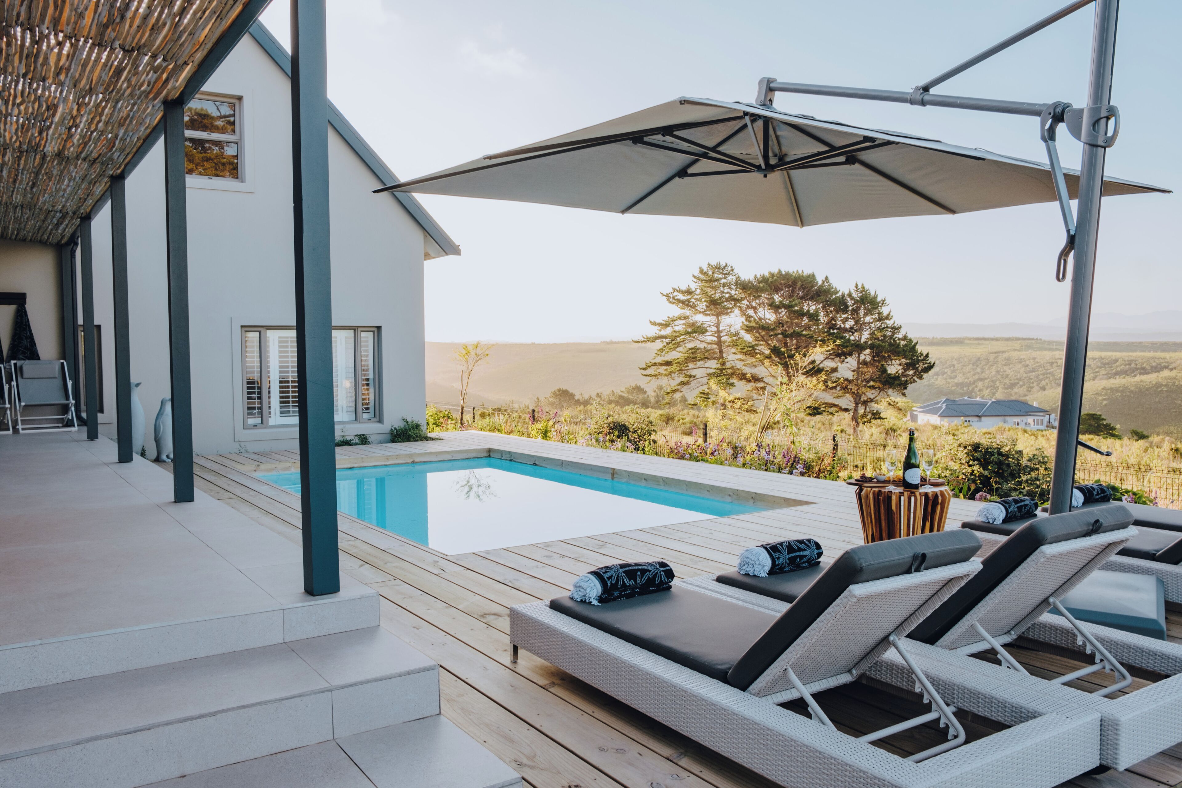 A modern outdoor pool area with lounge chairs and a pergola.