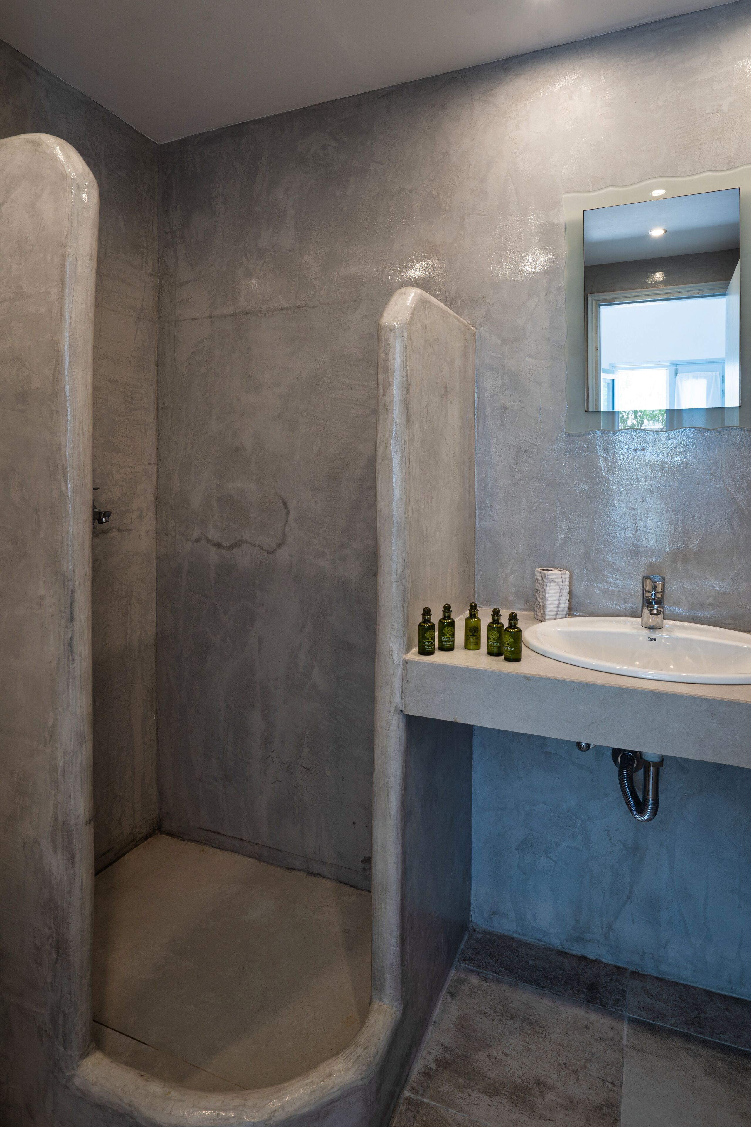 A bathroom with a shower, a sink, and a mirror.