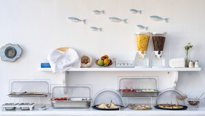 Un dispositiu de buffet amb diverses opcions de menjar i una decoració mural amb motius de peixos.