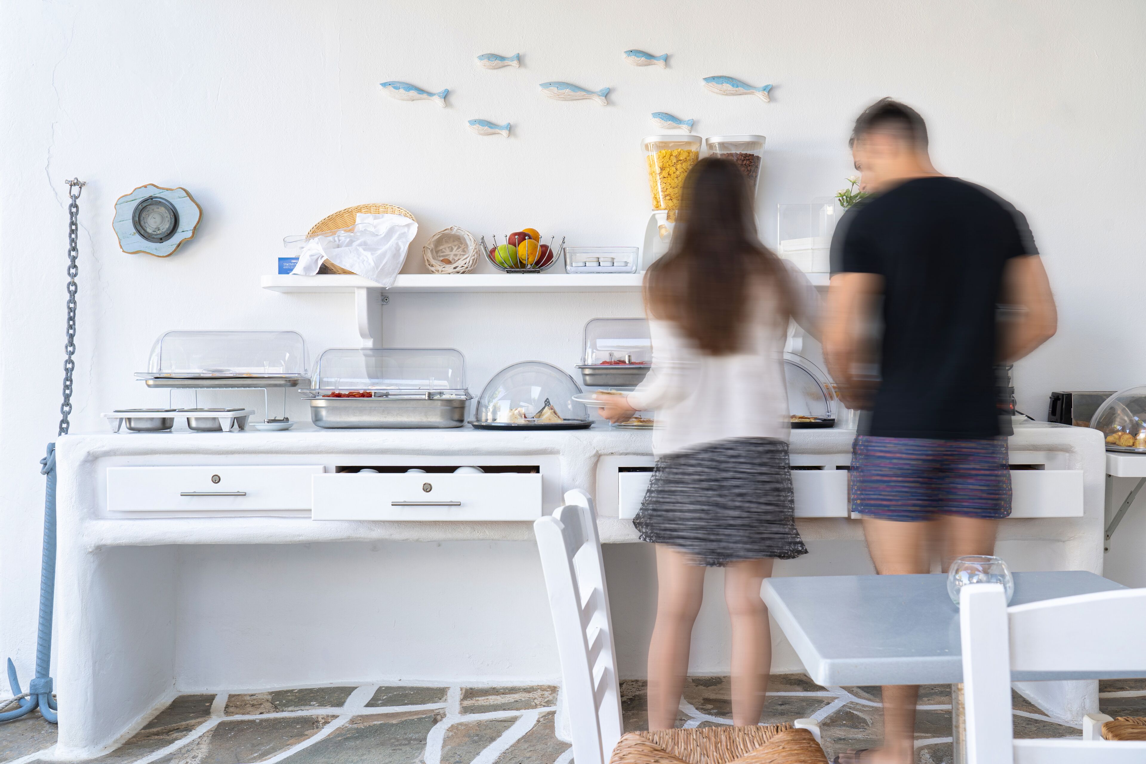 A kitchen area with white cabinets, a countertop, and a dining table.