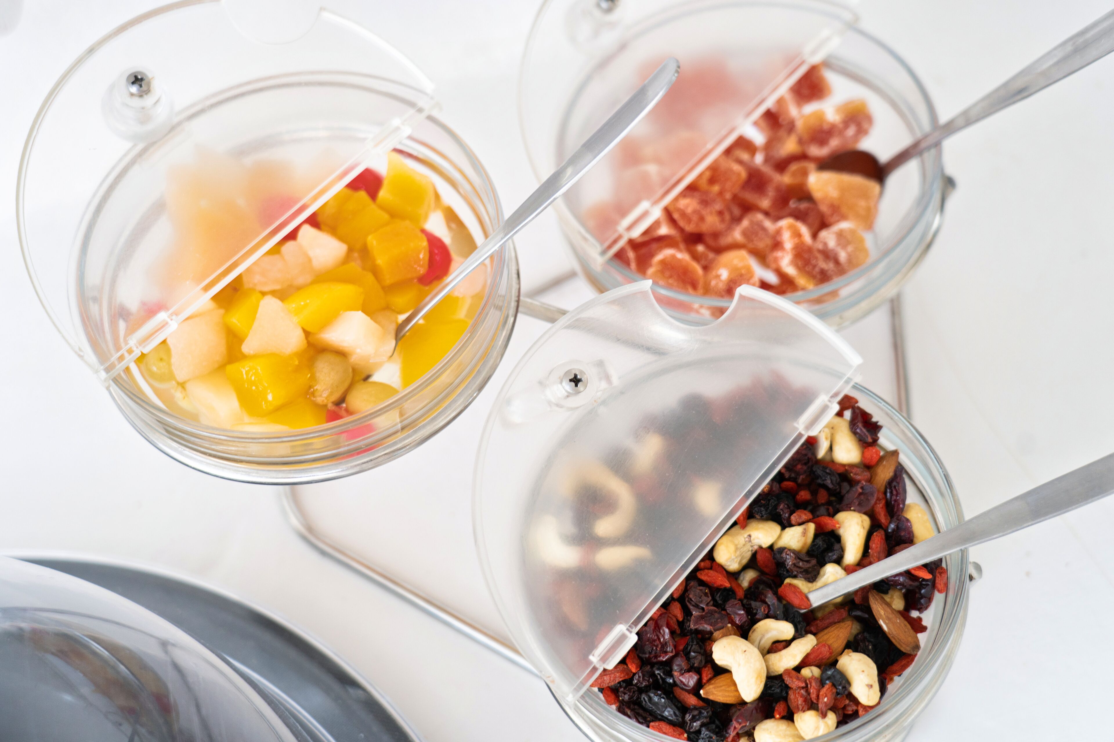 Tres recipientes de vidrio con tapas, cada uno conteniendo distintos alimentos.