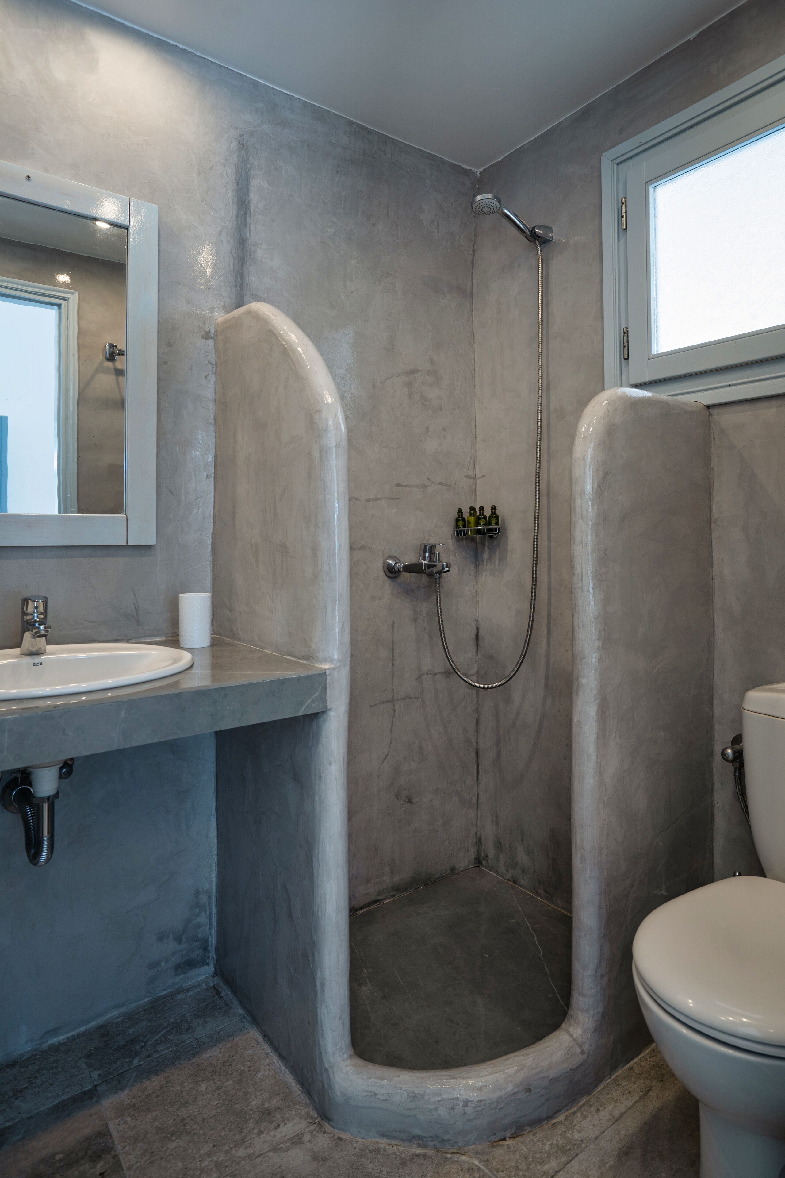 Une salle de bain équipée d’une douche, de toilettes, d’un lavabo et d’un miroir.