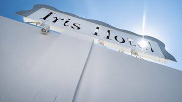 A sign with the name "Iris Hotel" mounted on a building.
