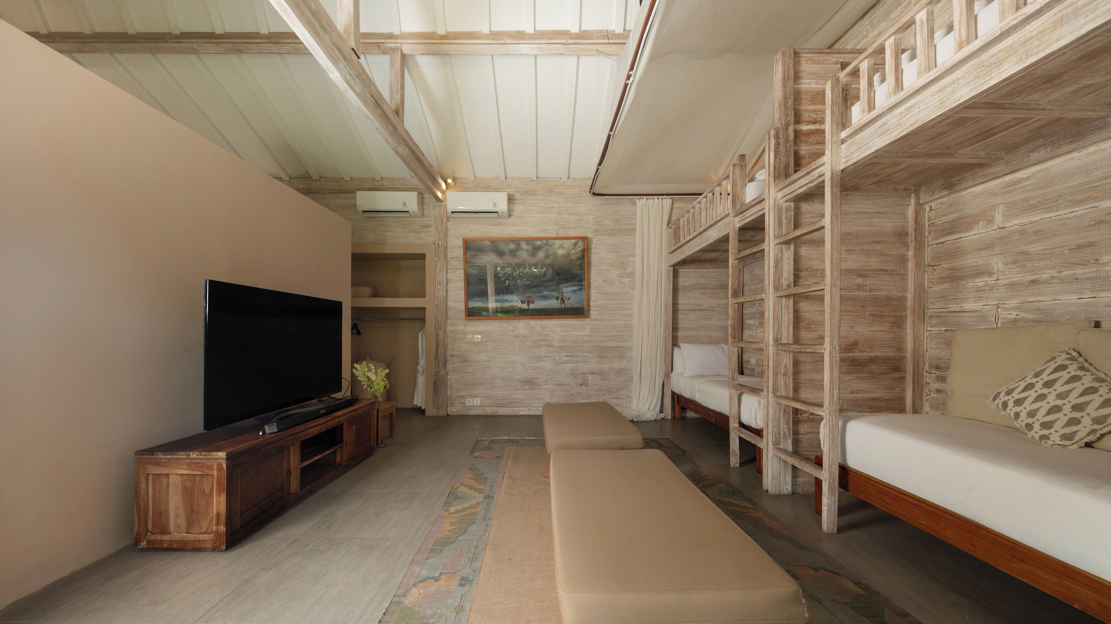 A modern living room with a television, sofa, and built-in shelving.
