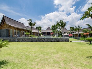 Un resort con varias villas de madera, una piscina y un muro de piedra en primer plano.
