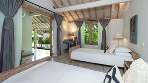 Quarto com cama, escrivaninha e cadeira. Tem uma janela com cortinas e vista para o verde lá fora.