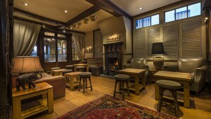 A cozy living room with a fireplace, wooden furniture, and a large rug. - The Feathers Hotel, Ledbury, Herefordshire (Ledbury)