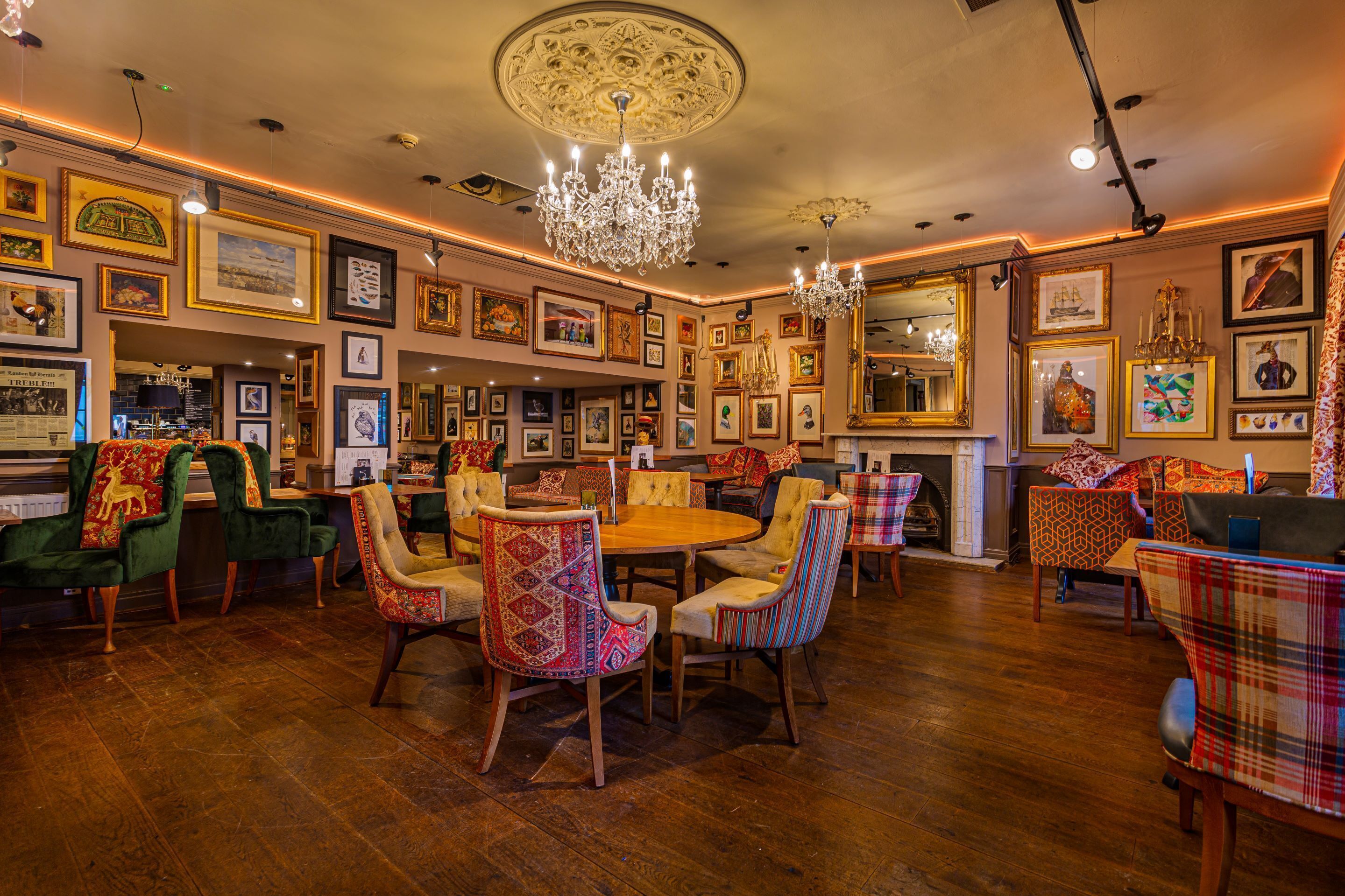 A dining area with a round table, chairs, and a chandelier.