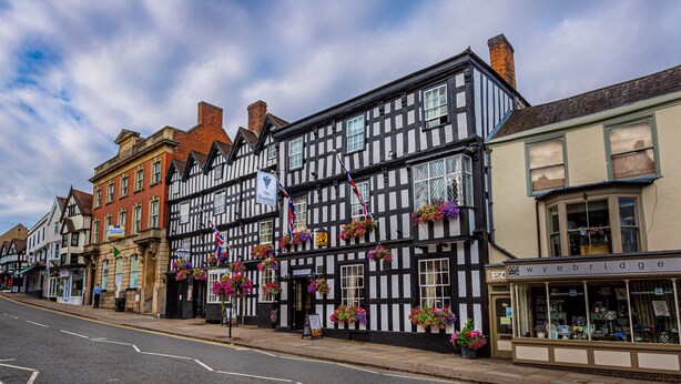 A traditional half-timbered building with flower boxes on the windows, a sign for 'The Feathers' pub, and a shop named 'Wye Bridge'. - The Feathers Hotel, Ledbury, Herefordshire (Ledbury)