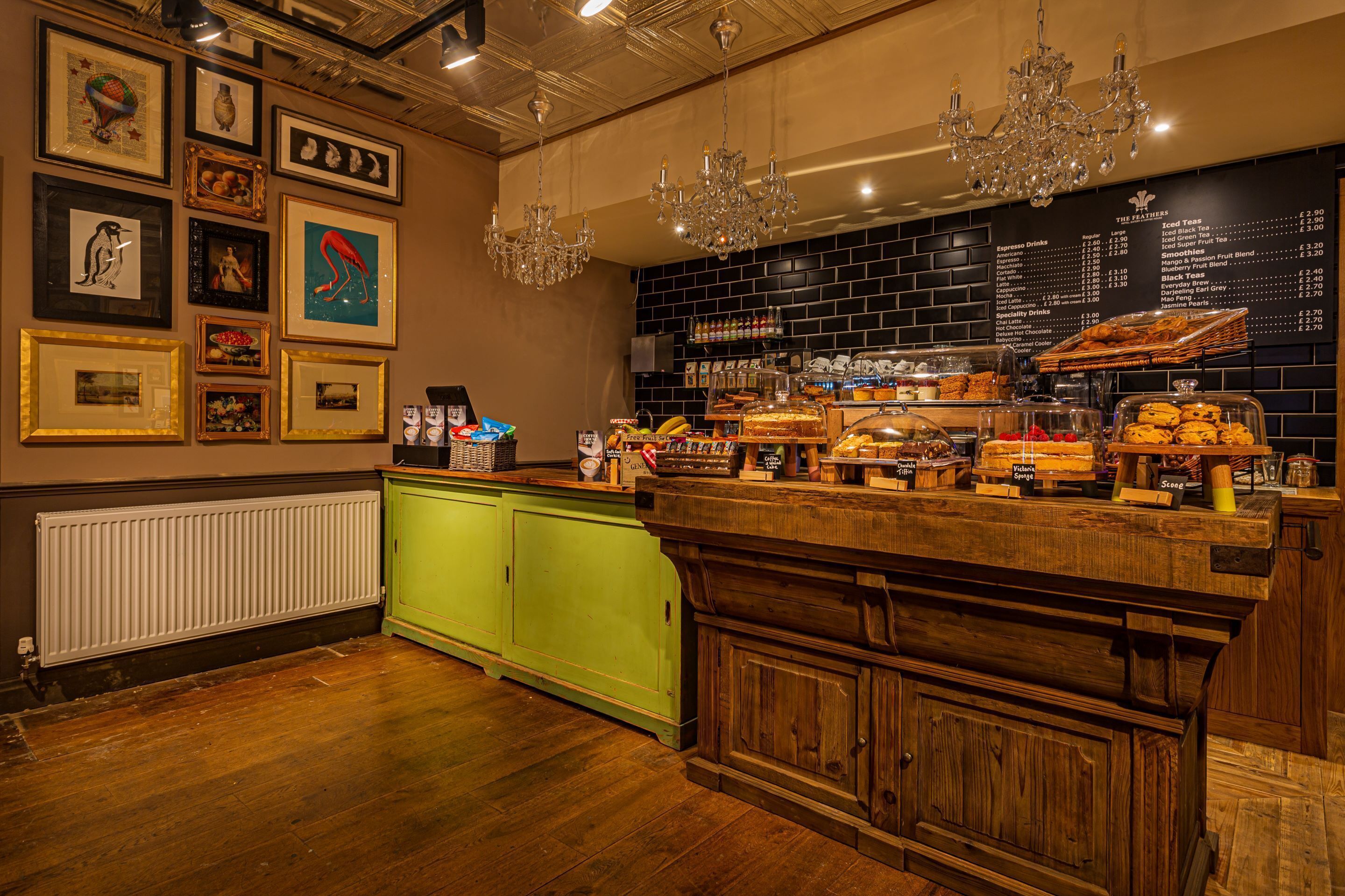 A bar area with a wooden counter, green cabinets, and a menu board.