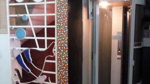 An elevator with a control panel and a decorative wall with abstract patterns. - Casas en MDQ Cordoba by EF (Mar del Plata)