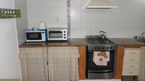 A kitchen with a microwave, toaster, stove, and oven. - Casas en MDQ Cordoba by EF (Mar del Plata)