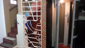 A staircase with a decorative white gate and a colorful mosaic wall. - Casas en MDQ Cordoba by EF (Mar del Plata)