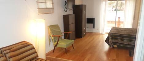 Una habitación con cama, silla, escritorio y armario.