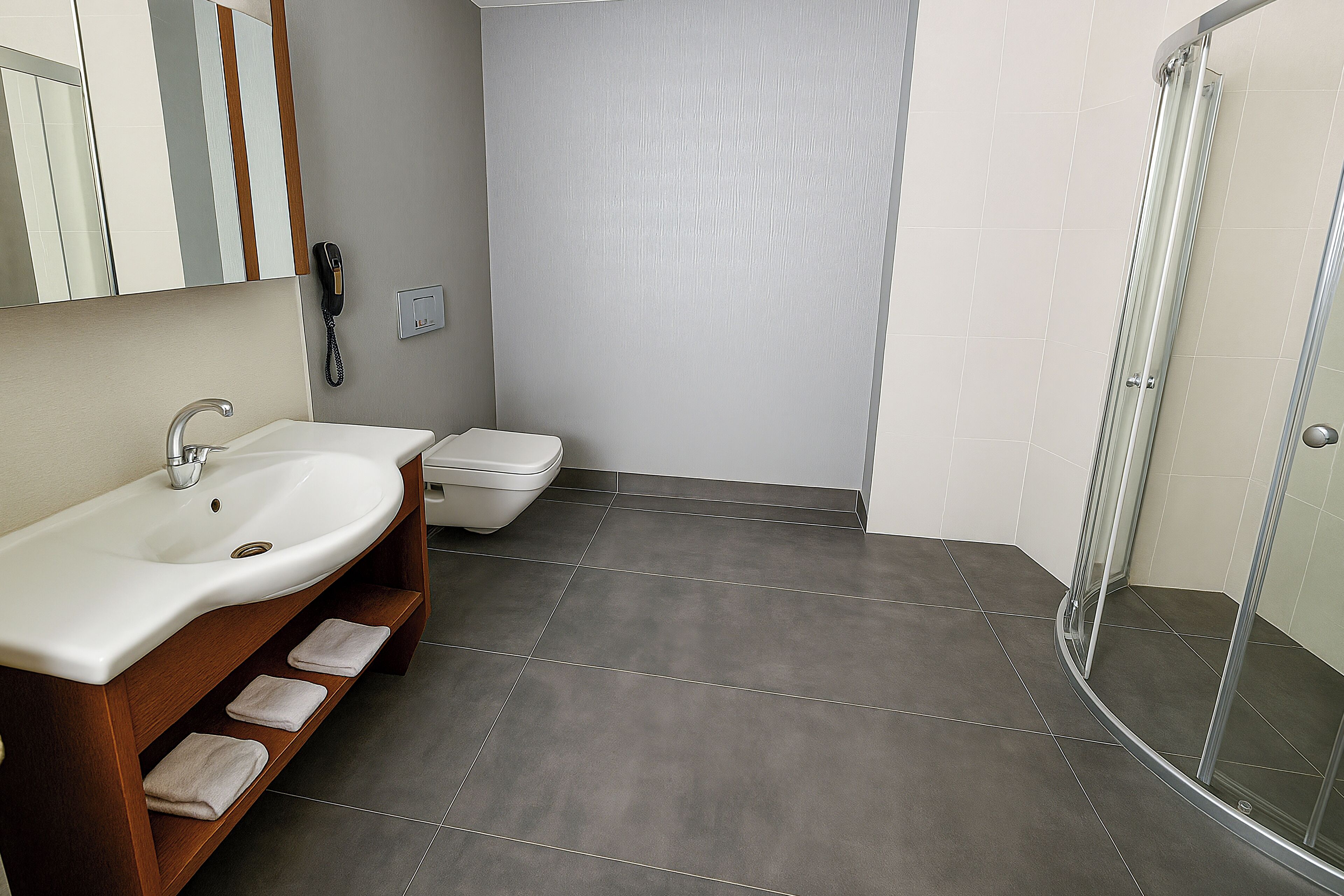 A bathroom with a sink, toilet, and shower.