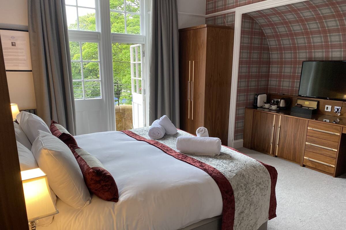 Une chambre d’hôtel avec un grand lit, une télévision et une armoire.