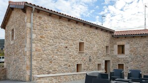 A stone building with multiple windows and a tiled roof. - El Abrigaño del Cañon I y II (Valle de Sedano)