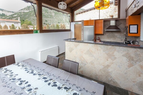 Una cocina moderna con salpicadero de piedra, horno integrado y vistas al exterior.