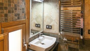 A bathroom with a white sink, a mirror, and a towel rack.