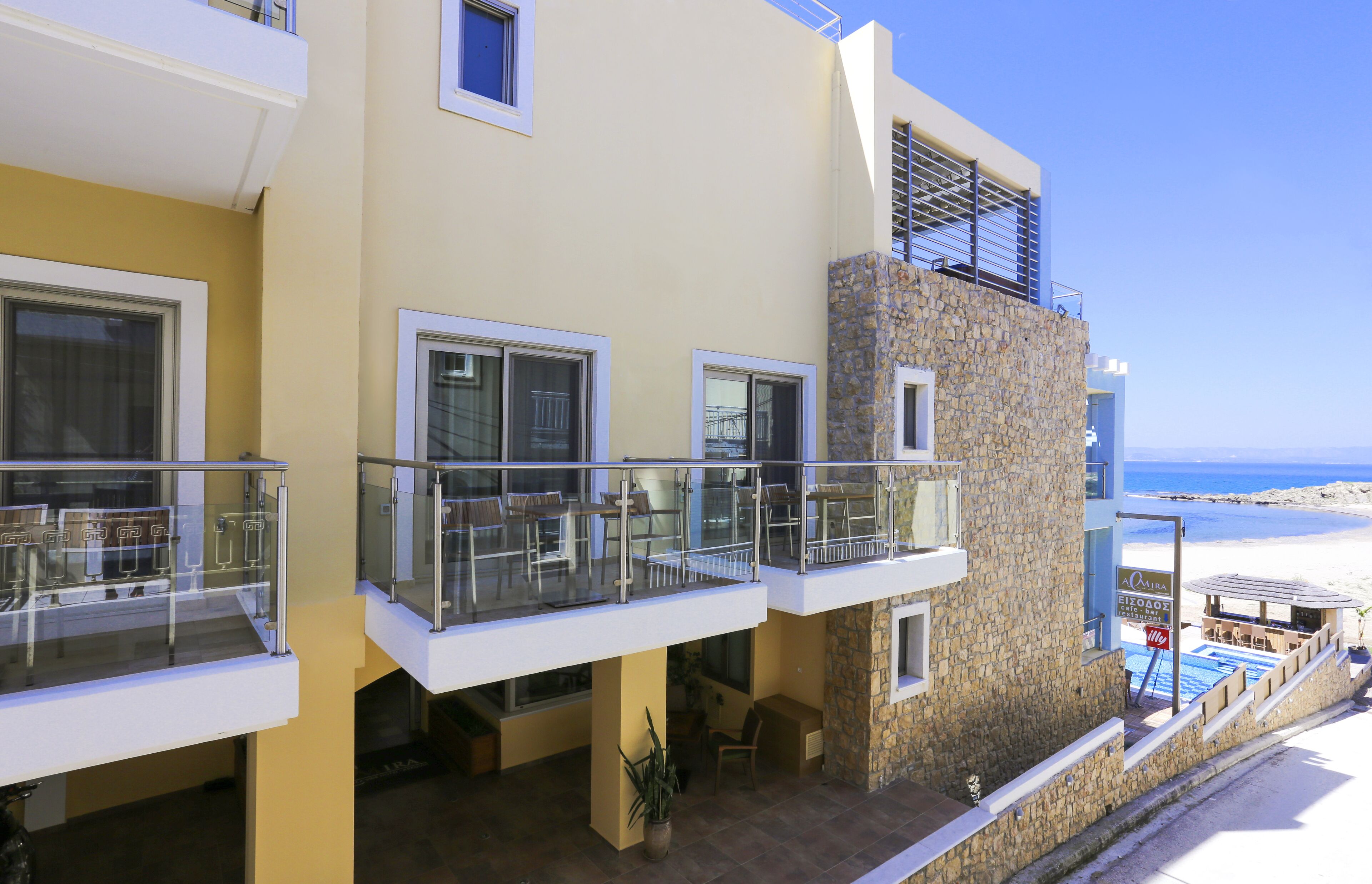 A modern hotel with balconies, a pool, and a view of the beach.