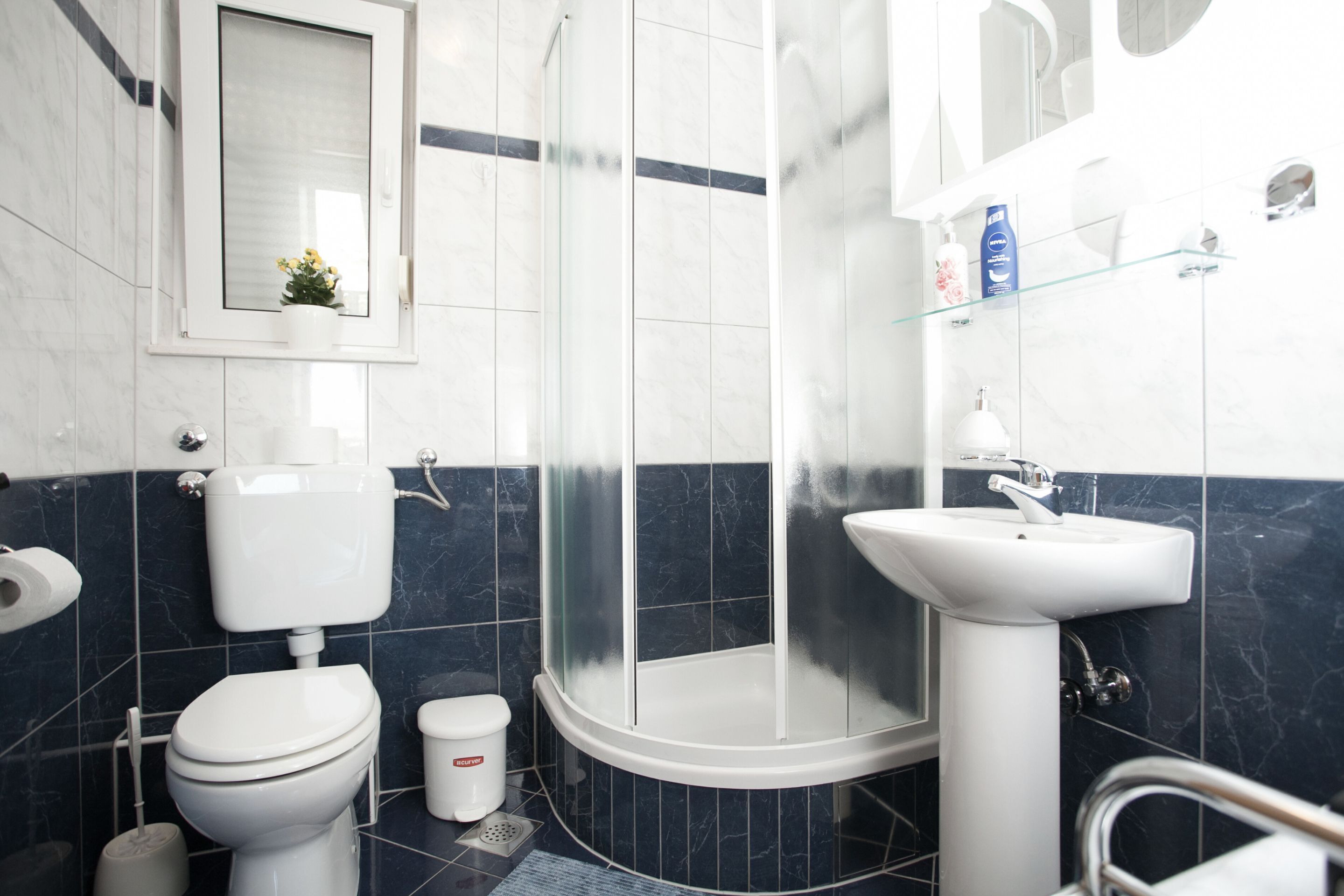 A modern bathroom with a toilet, sink, and shower.