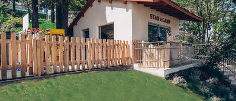 A small building labeled "Star Camp" with a wooden fence, a basketball hoop, and a staircase leading to the entrance.