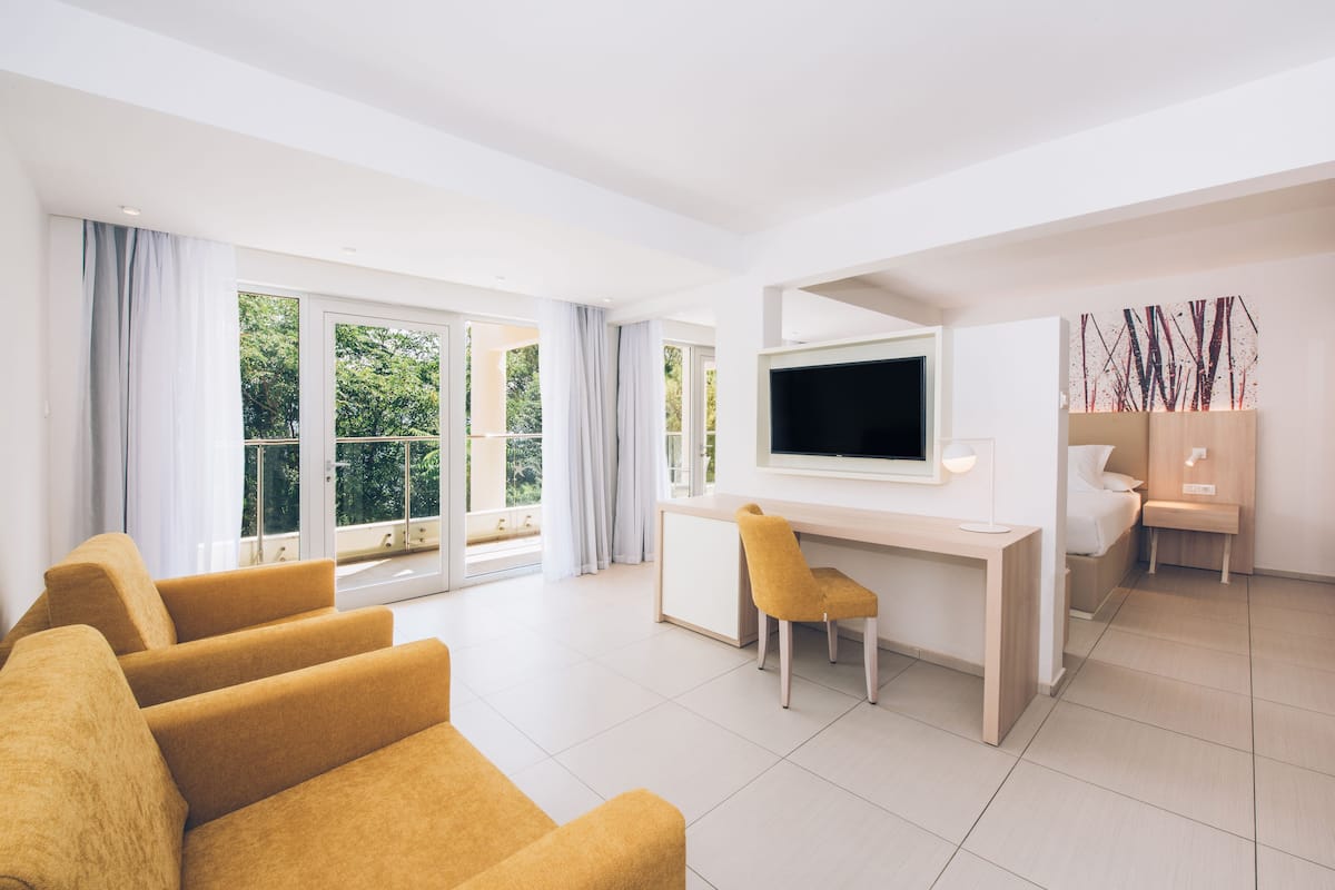 Uma sala de estar moderna com um sofá, uma escrivaninha e uma televisão.
