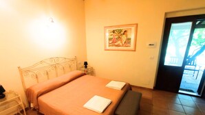 A bedroom with a bed, bedside table, bench, and a painting on the wall. - Don Federico Country Inn (Moscufo)