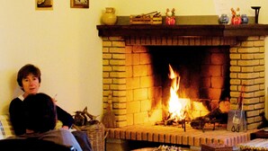 A living room with a brick fireplace, a sofa, and a table with a candle. - Don Federico Country Inn (Moscufo)