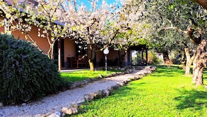 A garden with a pathway leading to a covered seating area. - Don Federico Country Inn (Moscufo)