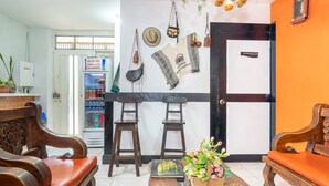 A lobby with wooden furniture, a refrigerator, a clock, and a door labeled "ADMINISTRACION". - Ayenda 1422 Caney (Cali)
