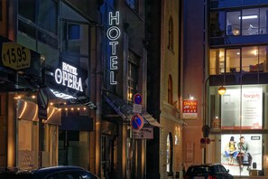 A hotel named "HOTEL OPERA" with a neon sign, a price sign of €15.95, and a sign for "Drachen City".