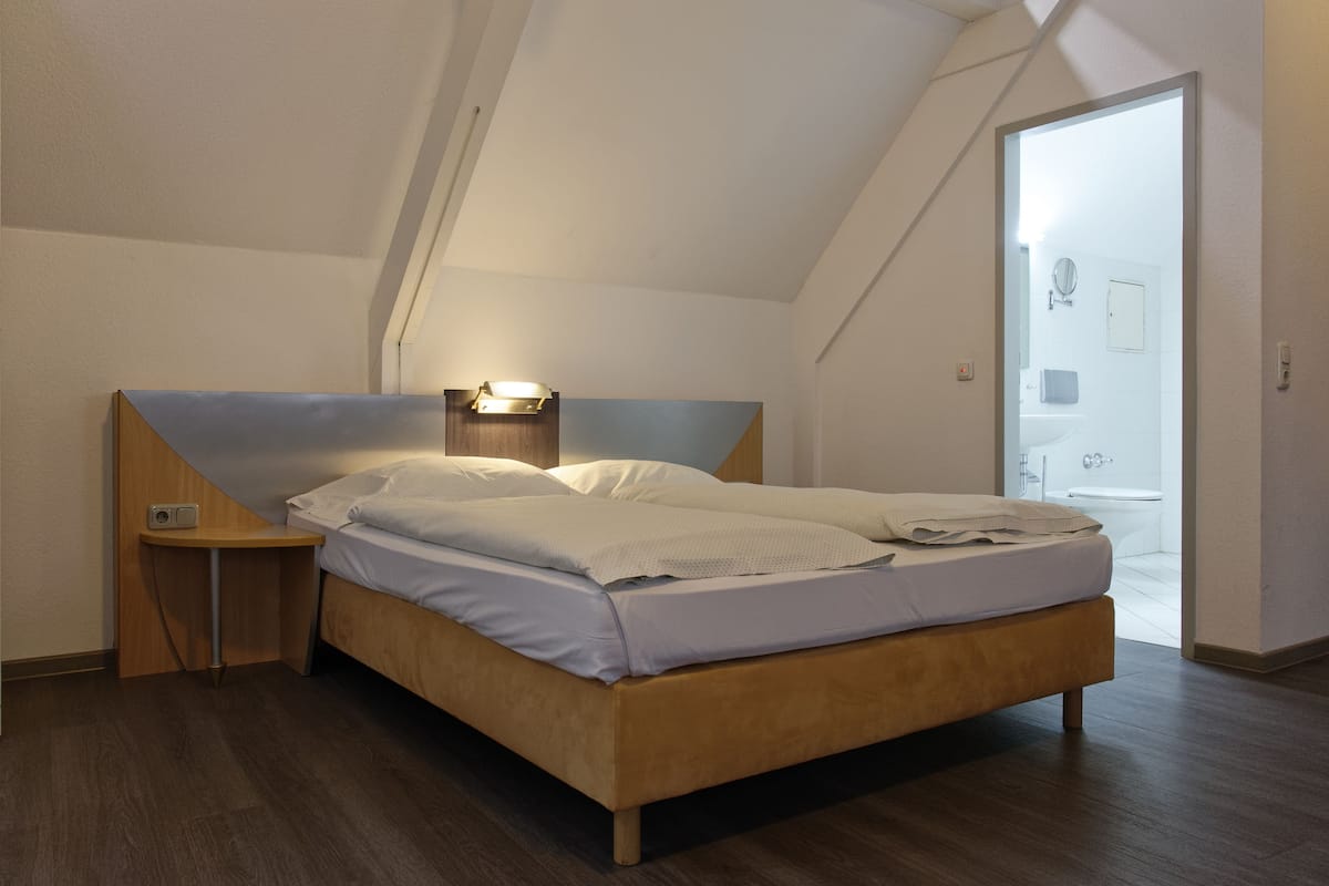 Ein Schlafzimmer mit einem hölzernen Bett, einem Nachttisch und einem Beistelltisch.