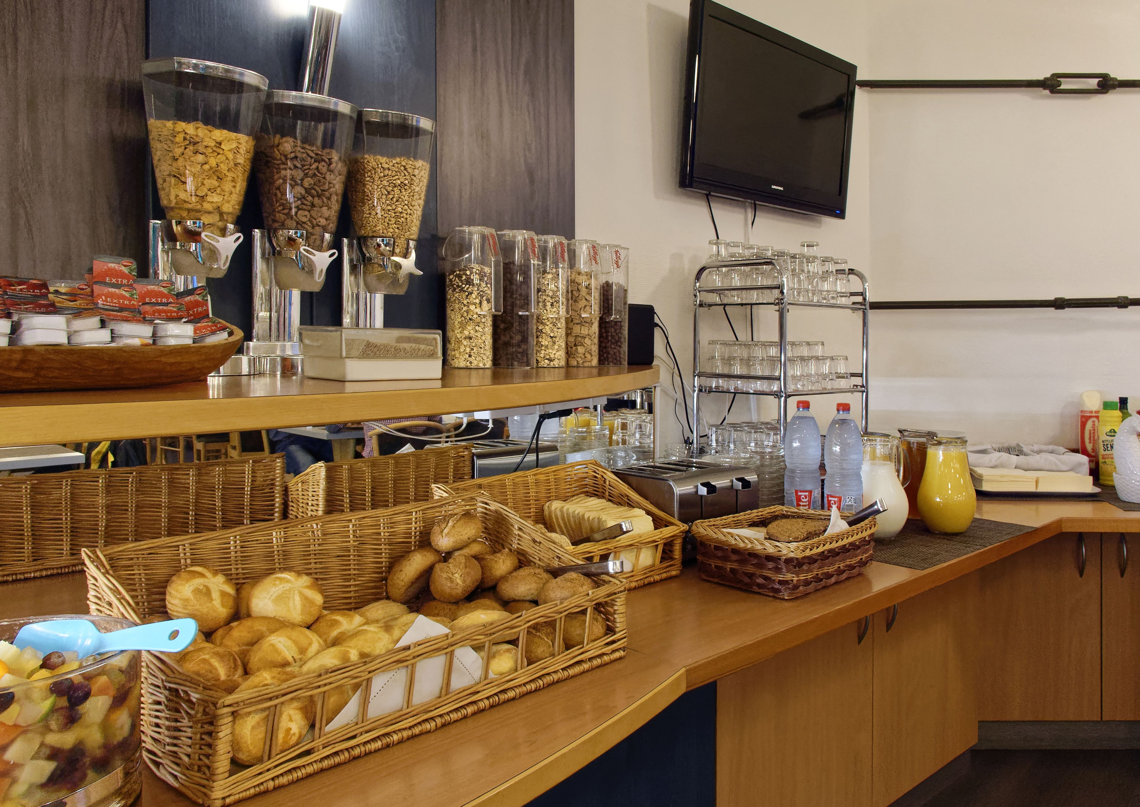 Un'area buffet con diversi cibi, tra cui frutta, pasticcini e bevande.