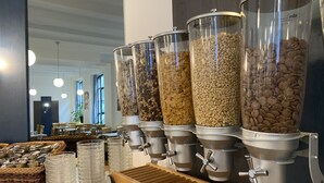 A buffet area with multiple dispensers filled with different types of food. - Opera Hotel Köln (Cologne)