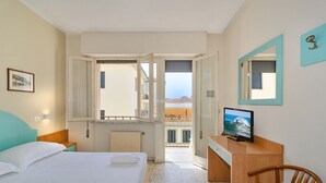 A hotel room with a bed, a desk with a TV, a chair, a window, and a balcony. - Hotel Stella d'Italia (Viareggio)